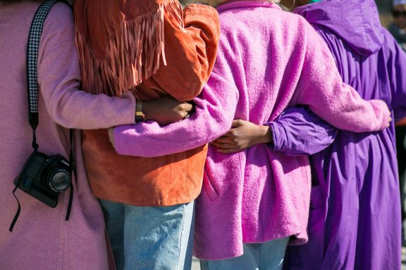 Women in pink and purple supporting each other